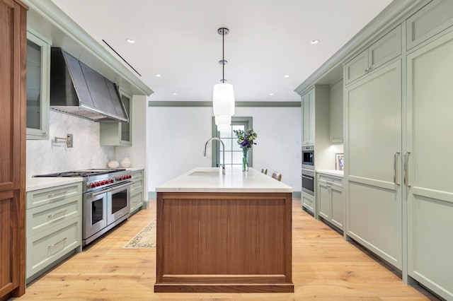 236 Pendleton Ave, Palm Beach, FL 33480 - kitchen featuring wall chimney exhaust hood, appliances with stainless steel finishes, green cabinetry, a sink, and light countertops