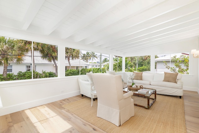 sunroom / solarium featuring vaulted ceiling with beams