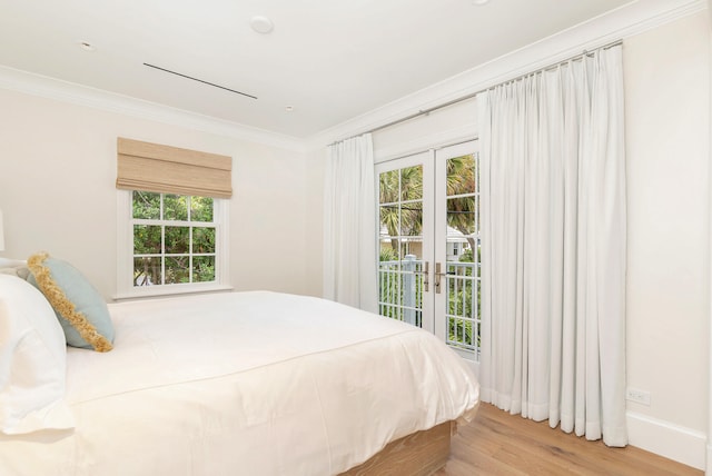 bedroom with access to outside, french doors, light wood-type flooring, and multiple windows