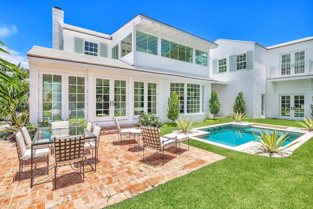 view of pool featuring a patio area, french doors, and a lawn