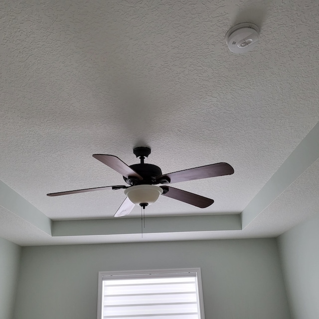 interior details featuring ceiling fan and a textured ceiling