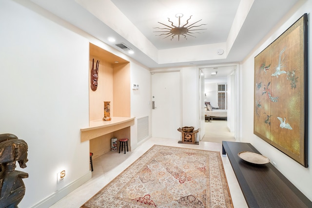 hallway with a raised ceiling