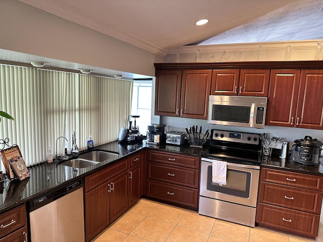 kitchen with appliances with stainless steel finishes, sink, dark stone countertops, vaulted ceiling, and ornamental molding