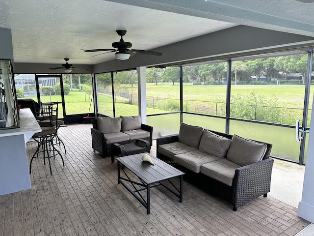 sunroom featuring ceiling fan