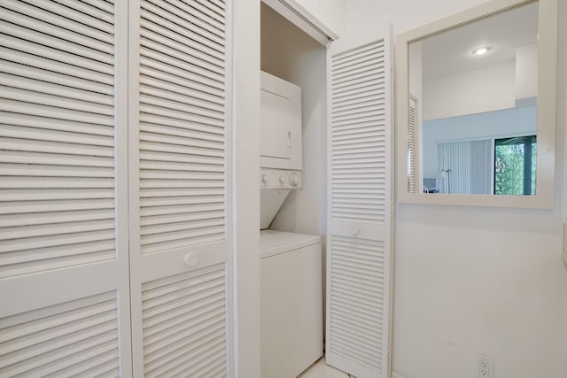 clothes washing area featuring stacked washer / drying machine