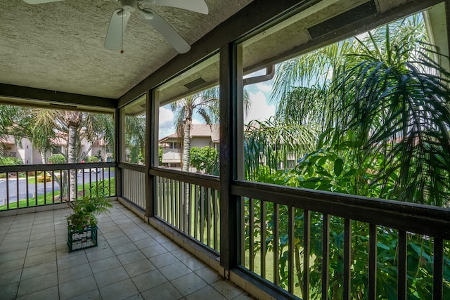 unfurnished sunroom with ceiling fan