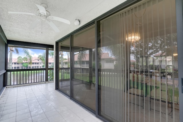 unfurnished sunroom featuring ceiling fan