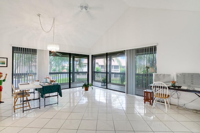 interior space with high vaulted ceiling and ceiling fan with notable chandelier