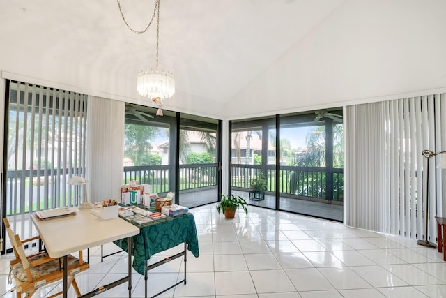 tiled dining space with high vaulted ceiling and ceiling fan with notable chandelier