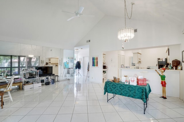 tiled living room featuring high vaulted ceiling and ceiling fan with notable chandelier