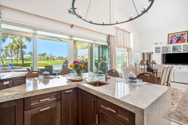 kitchen with a notable chandelier, sink, and dark brown cabinetry