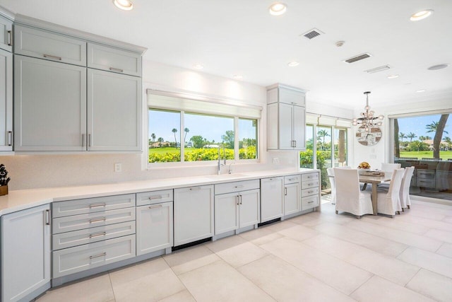 kitchen featuring light tile flooring, sink, pendant lighting, dishwasher, and ornamental molding