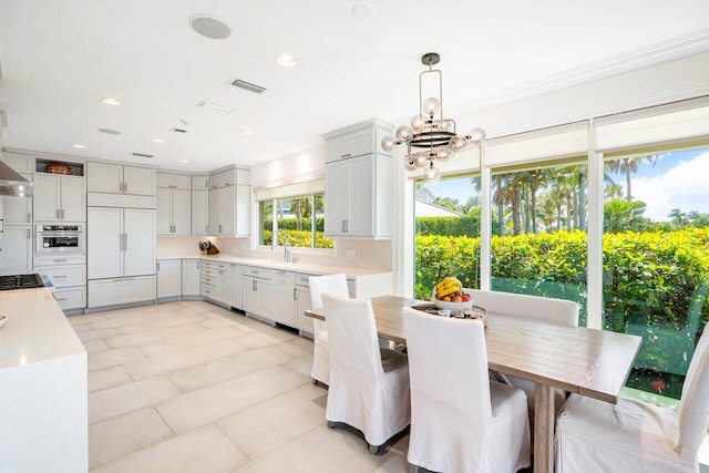 dining room featuring light tile floors, ornamental molding, and a chandelier