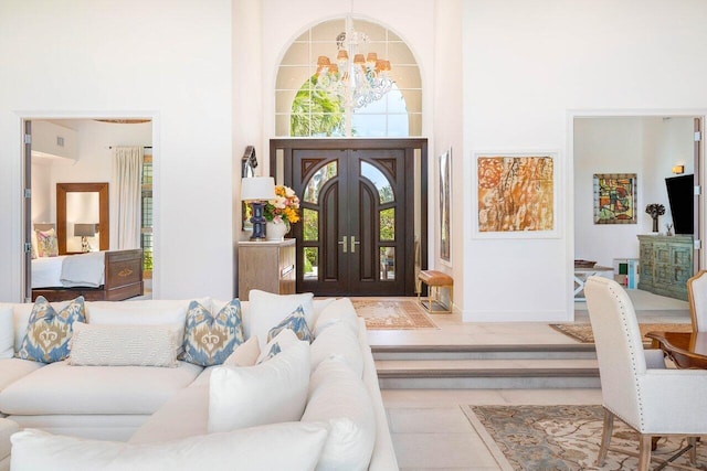 tiled foyer with a high ceiling, a chandelier, and a wealth of natural light