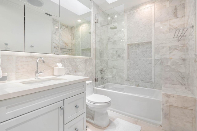 full bathroom with tile walls, tiled shower / bath combo, toilet, tile flooring, and large vanity