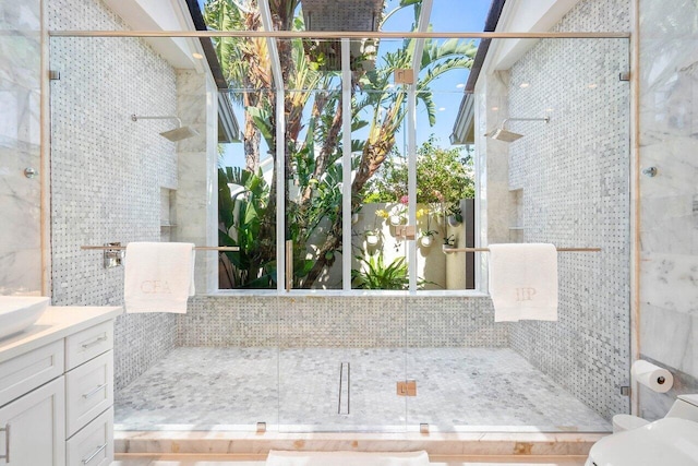 bathroom with toilet, an enclosed shower, and vanity