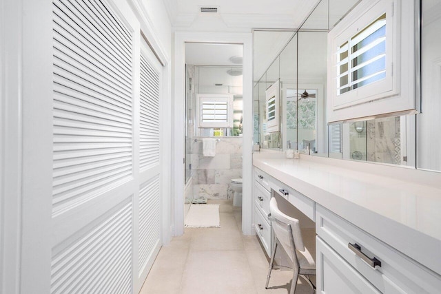 bathroom with tile flooring, oversized vanity, toilet, and tile walls