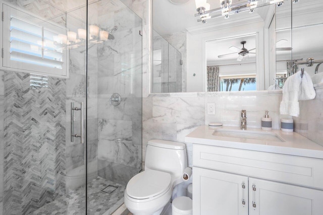 bathroom featuring tile walls, toilet, ornamental molding, oversized vanity, and ceiling fan with notable chandelier