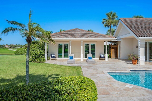 back of property featuring french doors, a yard, and a patio area