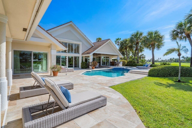 view of swimming pool featuring a yard and a patio