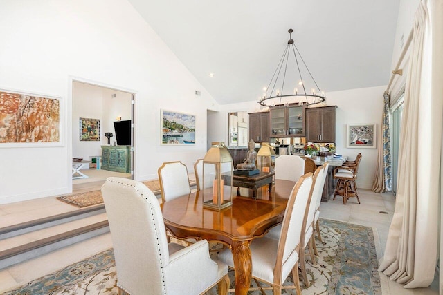 dining space with high vaulted ceiling, light tile flooring, and a notable chandelier