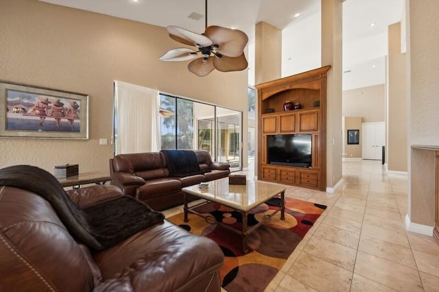 living room with a towering ceiling and ceiling fan