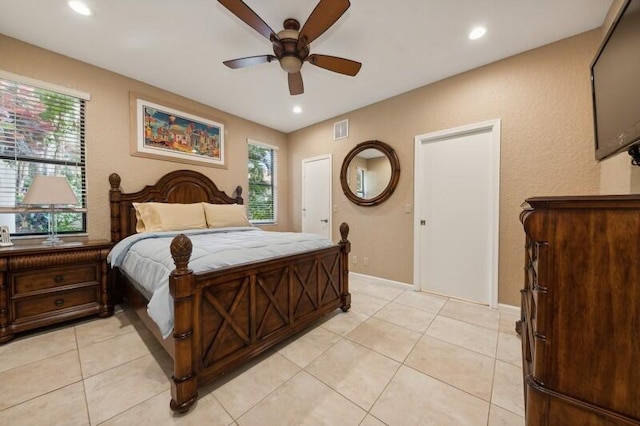 tiled bedroom featuring multiple windows and ceiling fan