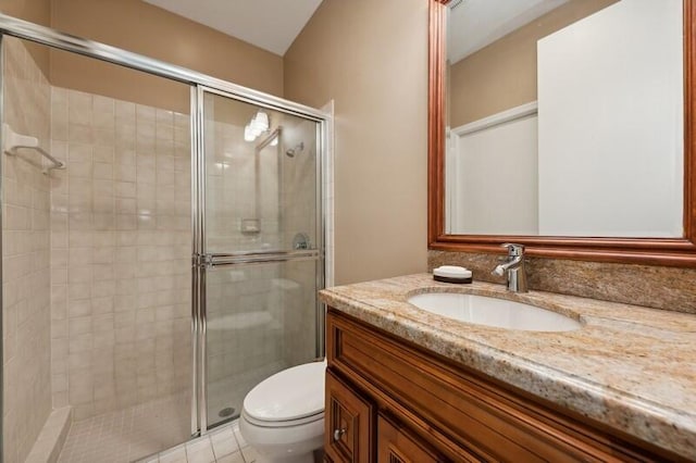 bathroom with vanity, toilet, tile patterned floors, and walk in shower