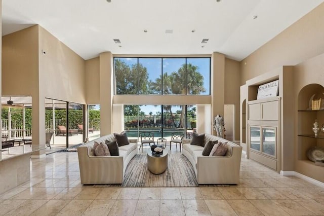 living room with built in features and a towering ceiling