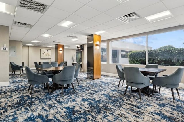 dining space featuring a drop ceiling and carpet floors