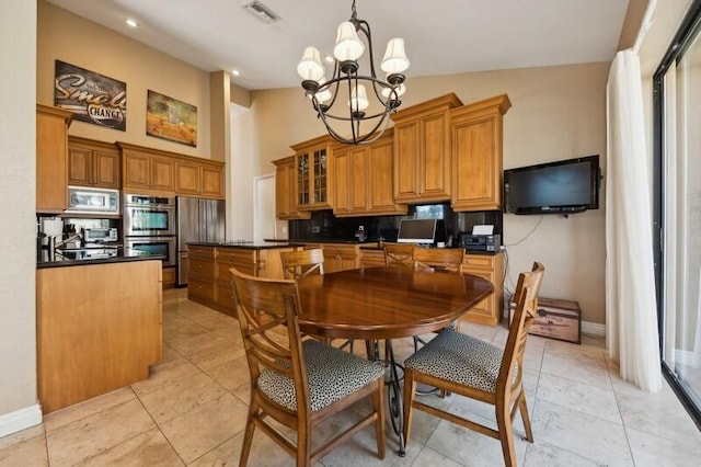 dining area with a chandelier, vaulted ceiling, and light tile patterned flooring