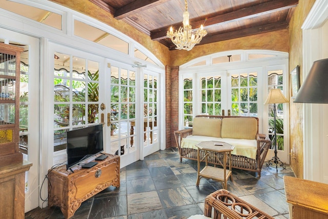 sunroom with wood ceiling, a chandelier, beam ceiling, and french doors