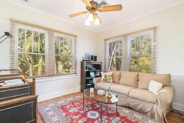 living room with ceiling fan, a wealth of natural light, crown molding, and hardwood / wood-style floors