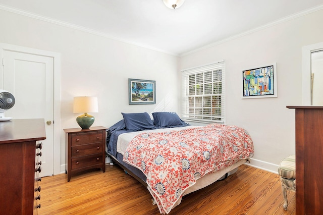 bedroom with light wood-type flooring and ornamental molding