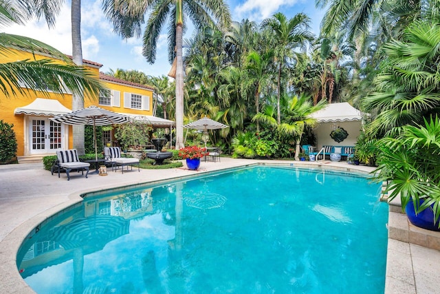 view of swimming pool with french doors and a patio