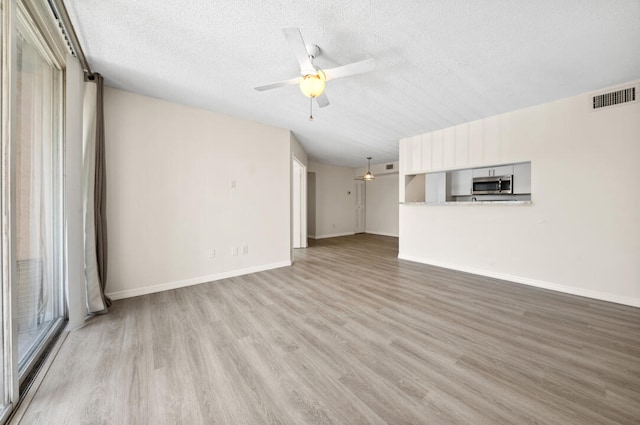 unfurnished room featuring a textured ceiling, ceiling fan, and hardwood / wood-style flooring