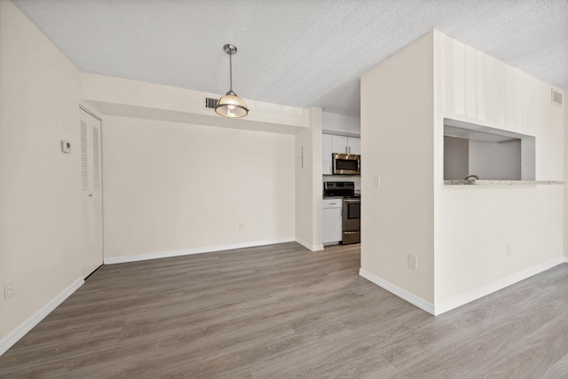 interior space with a textured ceiling and wood-type flooring