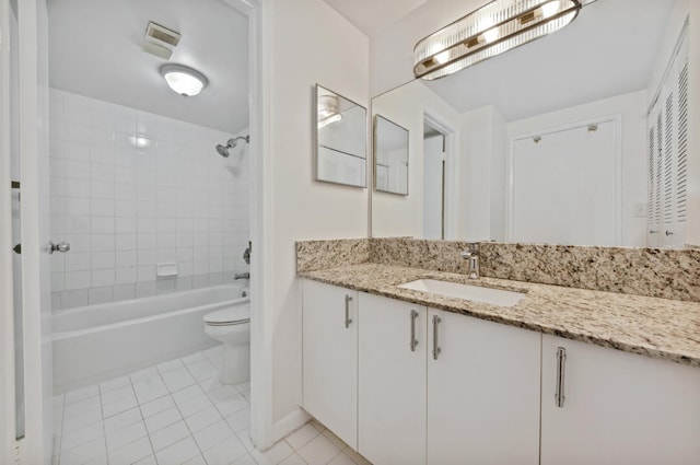 full bathroom with tile flooring, large vanity, toilet, and tiled shower / bath