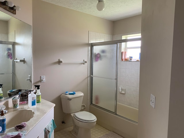 full bathroom with vanity, tile floors, a textured ceiling, bath / shower combo with glass door, and toilet