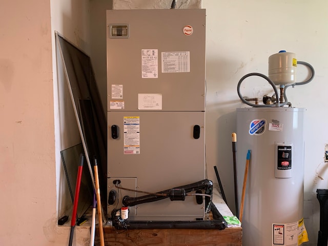 utility room featuring electric water heater and heating utilities