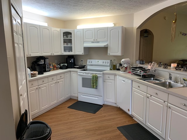 kitchen featuring white appliances, sink, light hardwood / wood-style floors, a textured ceiling, and white cabinetry