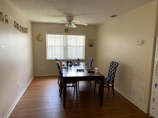 dining room featuring ceiling fan, a textured ceiling, and dark wood-type flooring