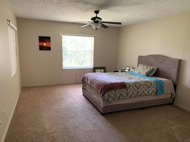 bedroom with a textured ceiling, dark carpet, and ceiling fan