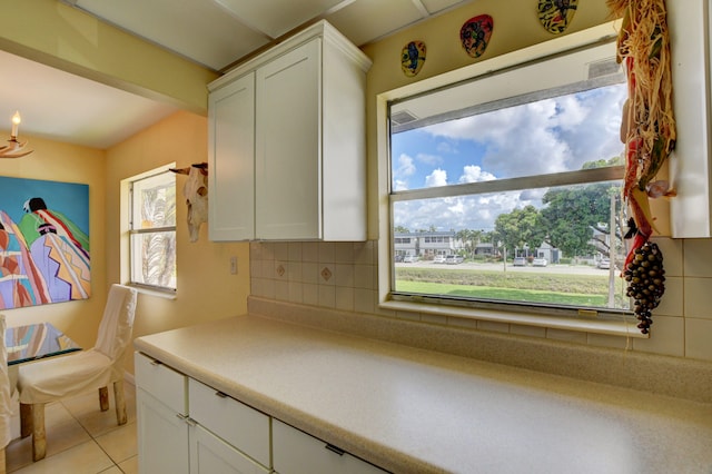 kitchen featuring light tile floors, white cabinetry, and tasteful backsplash