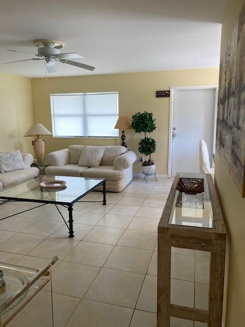 tiled living room featuring ceiling fan