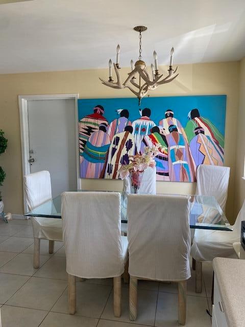 dining area with light tile flooring and an inviting chandelier