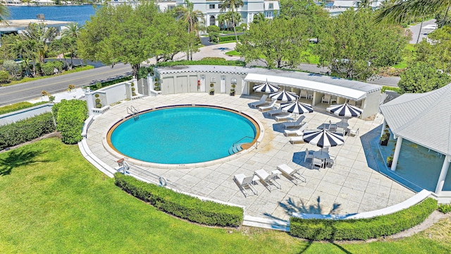 view of pool featuring a lawn and a patio