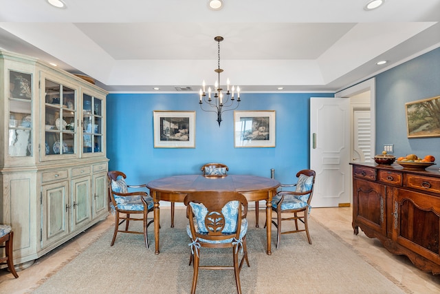 dining room with a tray ceiling, light tile floors, and an inviting chandelier