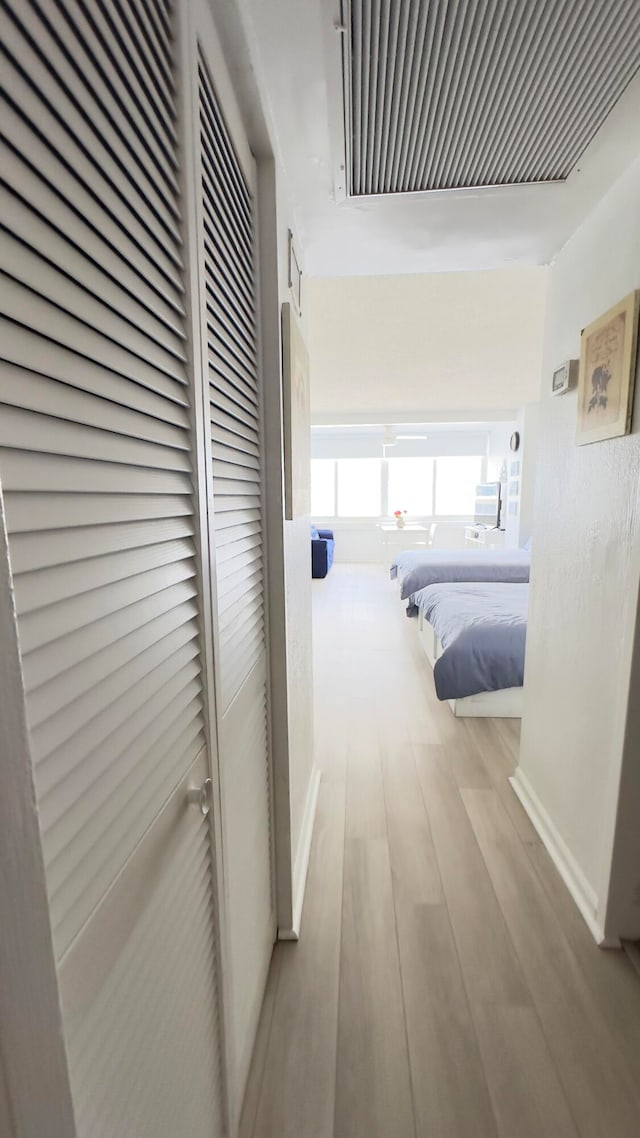 hallway with light hardwood / wood-style floors