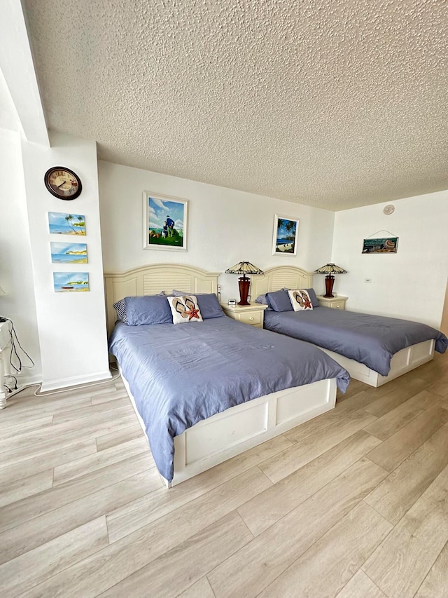 bedroom featuring a textured ceiling and light wood-type flooring